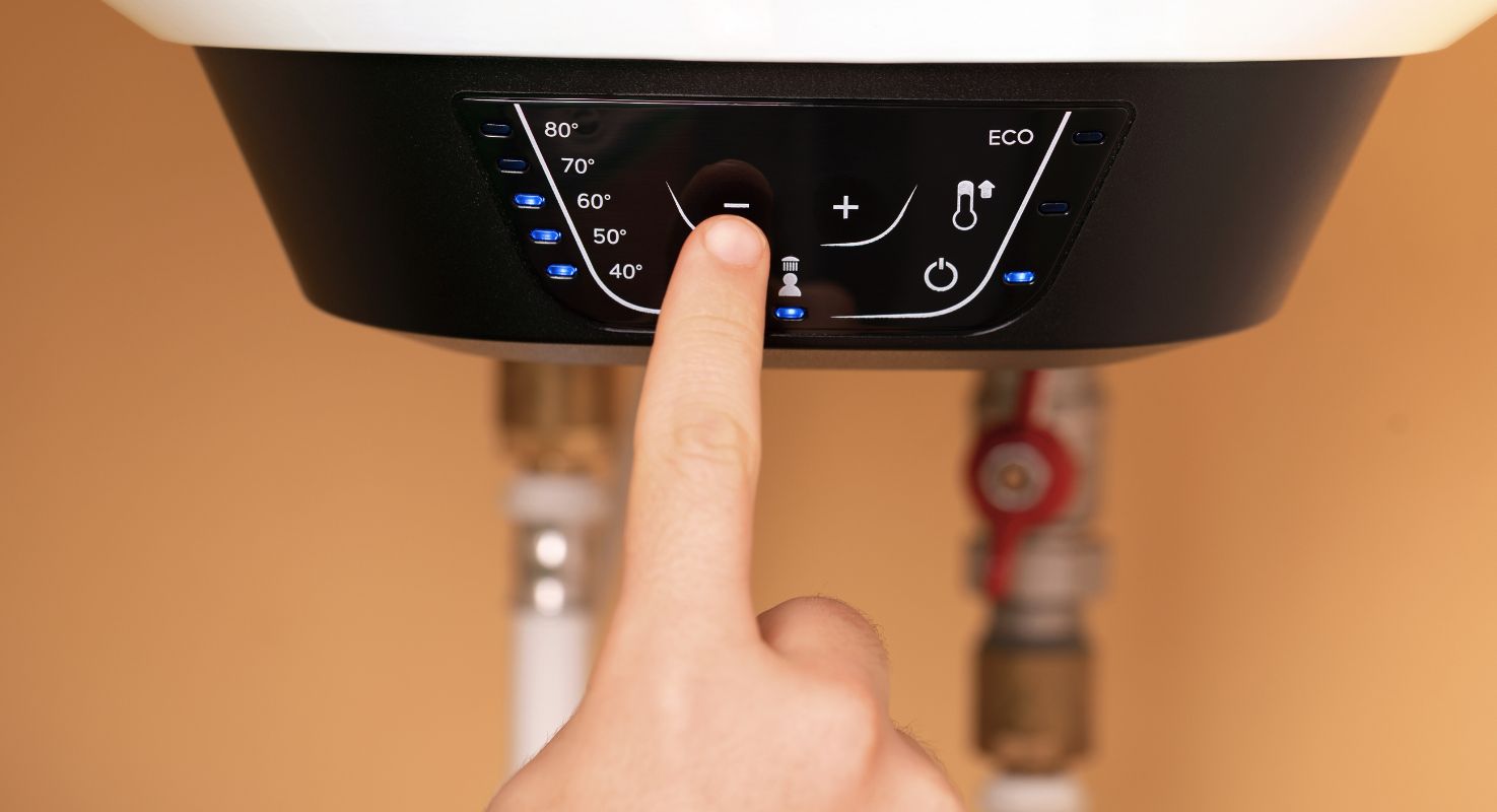 Ruka podešava temperaturu na digitalnom panelu električnog bojlera sa osvetljenim LED indikatorima i ECO funkcijom.