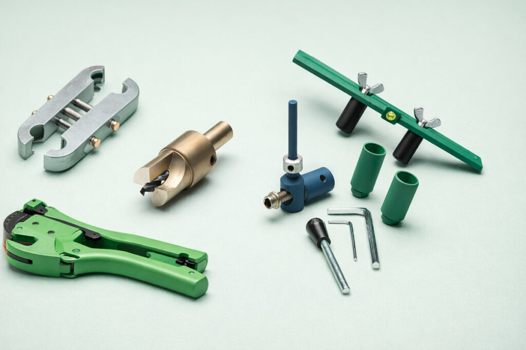 Set profesionalnih alata za vodovod i kanalizaciju raspoređen na neutralnoj pastelnoj pozadini