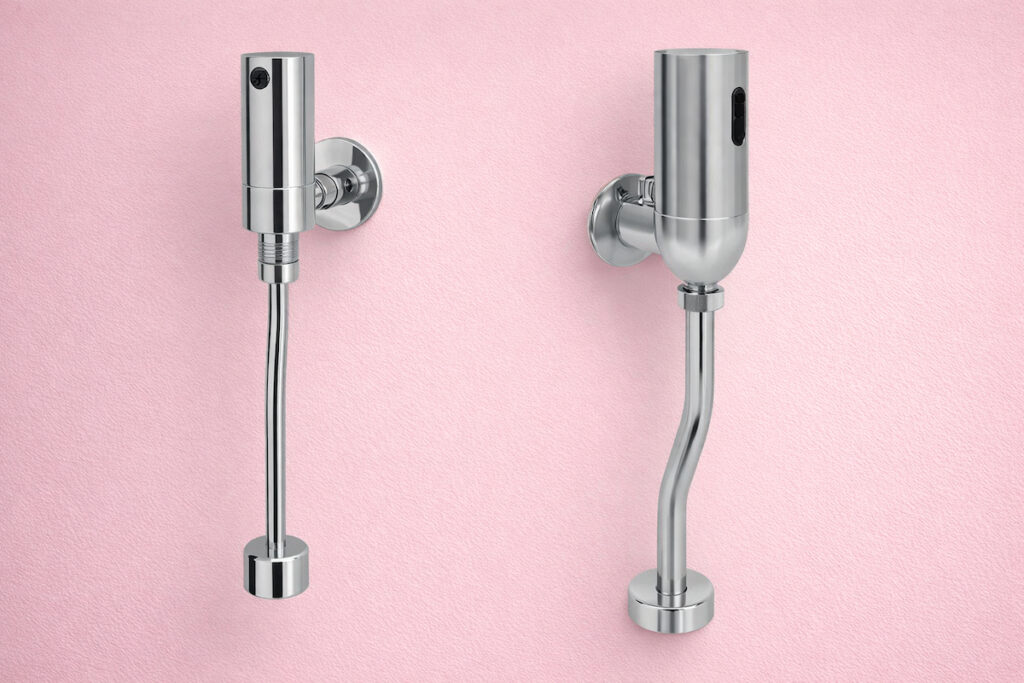 Dva senzorska ventila za pisoar od hromiranog metala, jasno vidljivi sa prednje strane