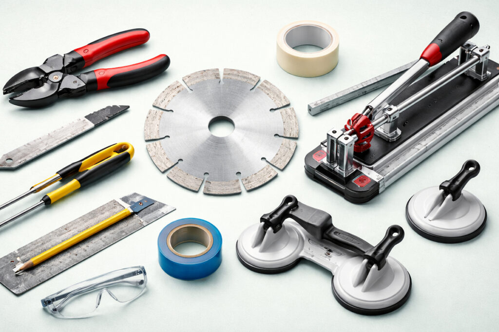 Dijamantska rezna ploča i alat za sečenje keramičkih pločica raspoređeni na pastelnoj pozadini